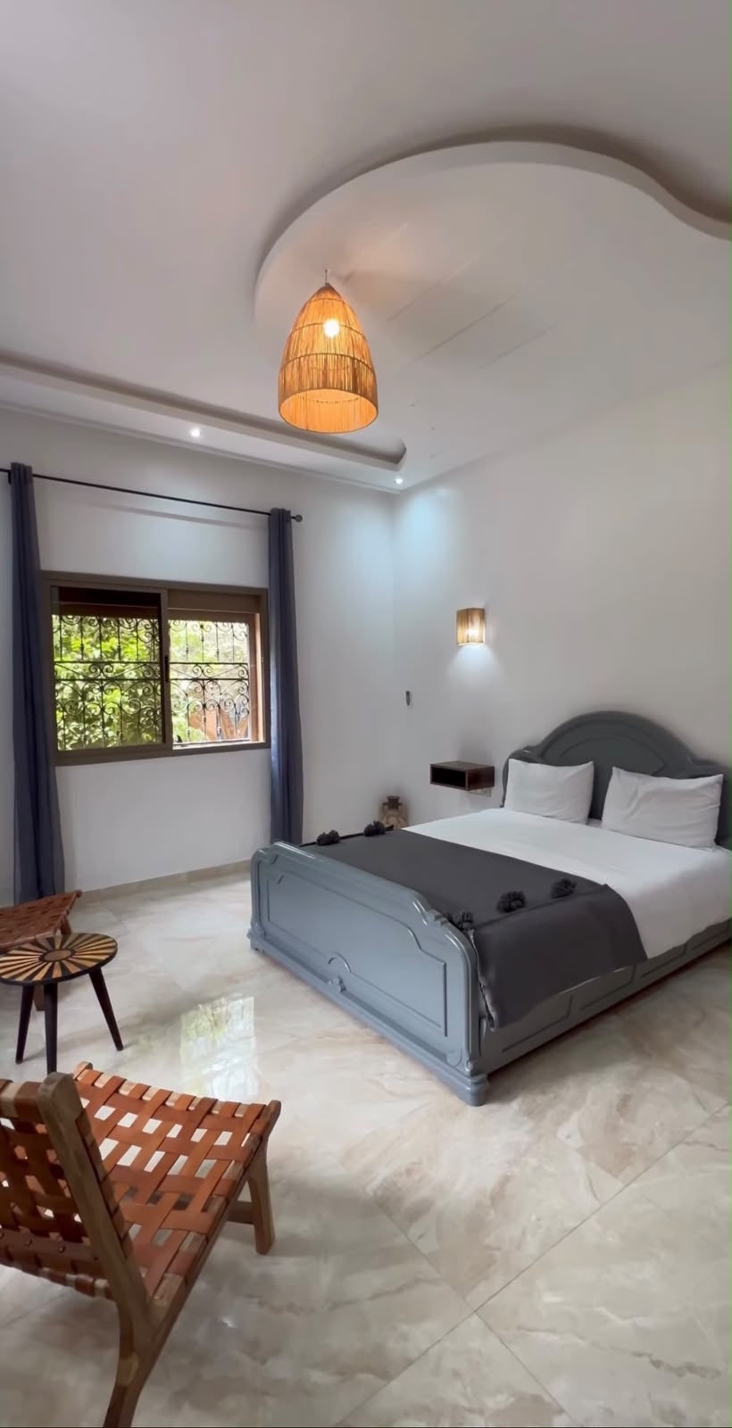 Chambre avec lit gris et suspension en osier